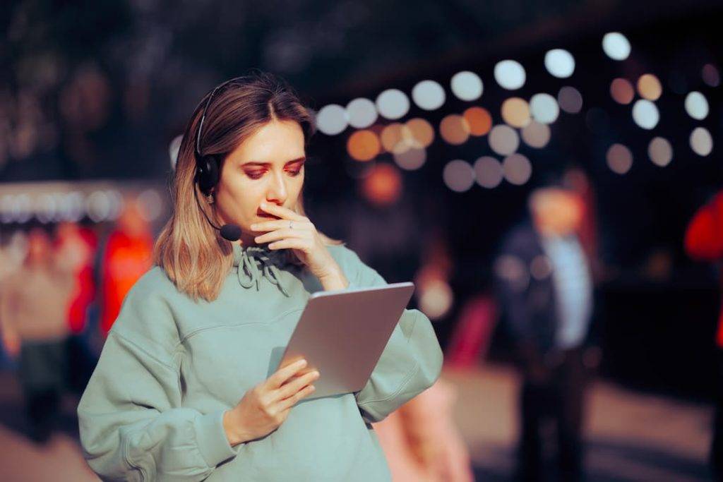 Female Festival Organiser Using A Tablet And Headset To Access Outdoor Wifi